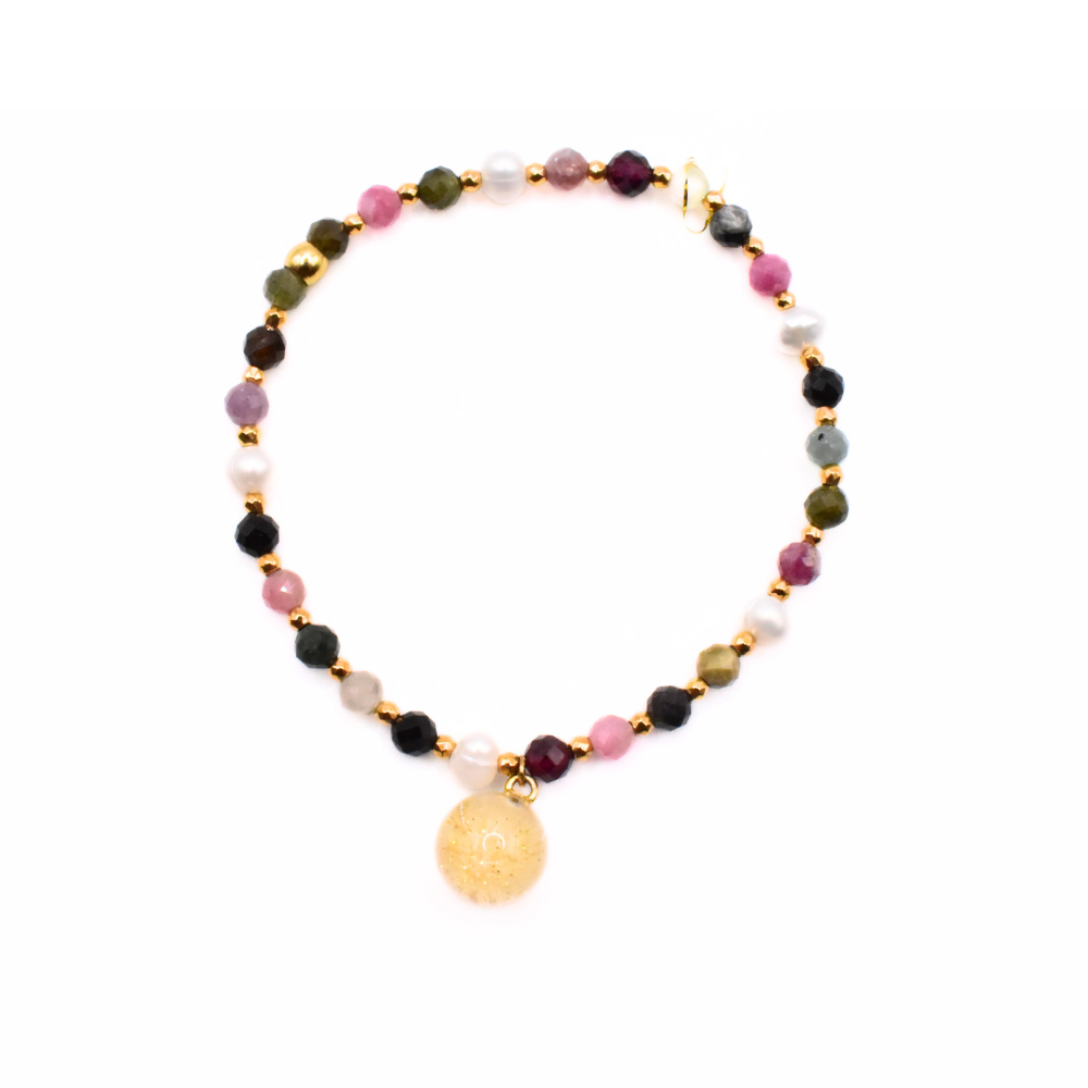 Bransoletka handmade z wielokolorowych kamieni i pereł, z zawieszką z żywicy w złotym odcieniu z dmuchawcem – widok z góry.