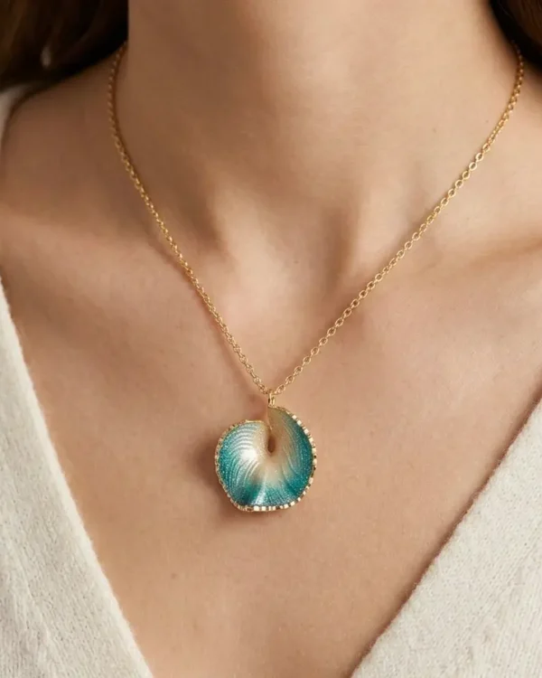 A close-up of a beautiful pendant necklace featuring a blue and gold design, worn on a person's neck.